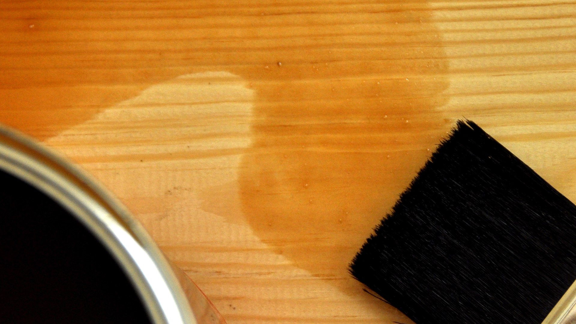 Brush with varnish on a wooden background 
