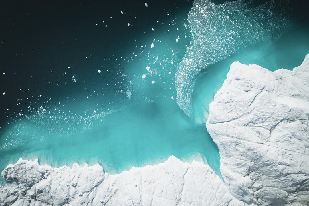 Bird's eye view of icebergs floating above the sea.