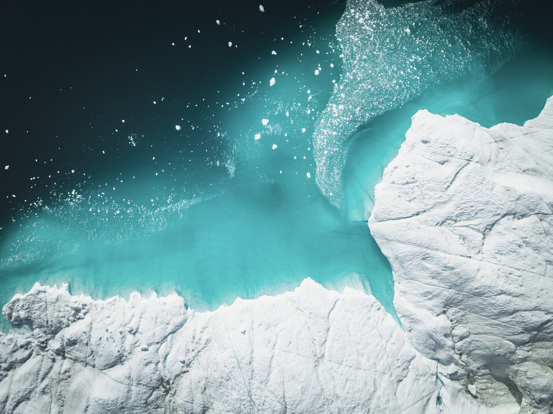 Über dem Meer schwebende Eisberge aus der Vogelperspektive.