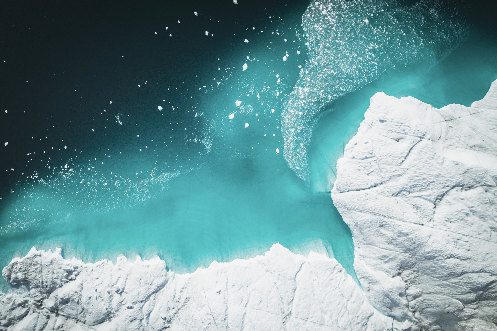 Bird's eye view of icebergs floating above the sea.