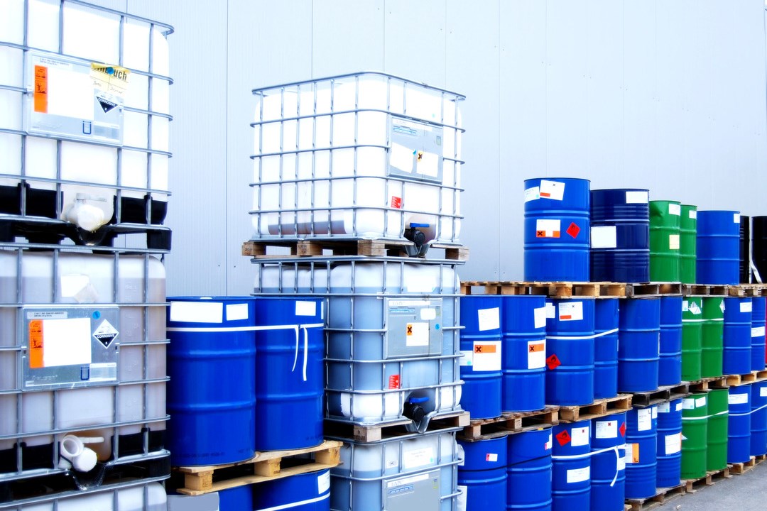 White container and blue drums on an industrial storage site