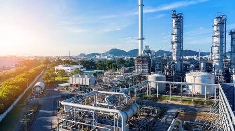 Aerial view of chemical oil refinery plant, power plant on blue sky background.