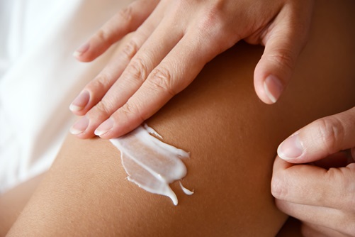 Woman put the cream on skin.